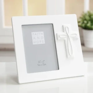 A beautiful white resin crucifix photo frame, measuring 3.5 x 5 inches, featuring the words 'Faith & Hope'. This elegant religious photo frame is perfect for displaying treasured memories from special occasions.