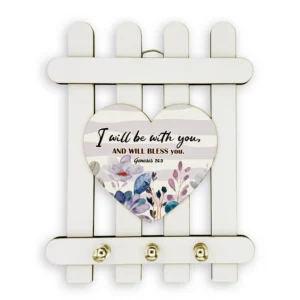 Wall-mounted wooden homeware key holder featuring the engraved Bible verse Genesis 26:3, displayed in a cozy entryway setting.