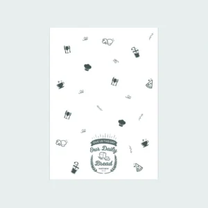 A decorative cotton tea towel from our homeware collection featuring the Bible verse Matthew 6:11, Give us this day our daily bread, displayed in colorful typography for kitchen decor.