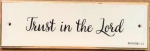 A minimalist ceramic hanging plaque featuring the inspirational message Trust in the Lord, part of the Pure and Simple home decor collection.
