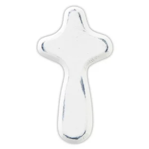 A small, smooth white prayer cross held in a hand, designed as a portable religious comfort gift for pocket or purse.