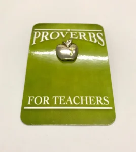 A metallic lapel pin featuring an apple and cross design, ideal as a Sunday school gift or a thoughtful present for teachers and school leavers.