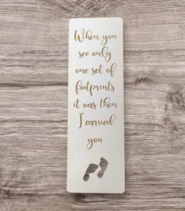A decorative bookmark featuring a footprints design, part of the Pens and Bookmarks collection supporting the Rock Foundation charity.