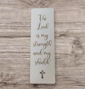 A decorative bookmark featuring the religious inscription The Lord is my strength and my shield, part of our inspirational pens and bookmarks collection.