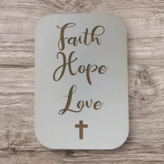 A decorative magnet featuring the words Faith, Hope, and Love, produced by the Rock Foundation charity to support disadvantaged individuals.