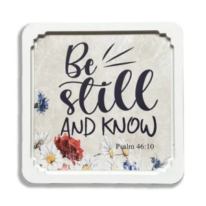 A square white frame featuring the inspirational quote Be still and know, displayed as a faith-inspired wall print within our collection of heavenly blessed gifts.