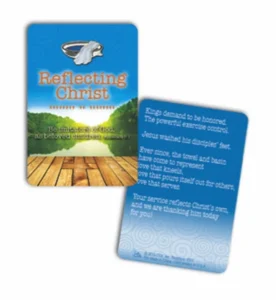 A decorative metal lapel pin and badge set featuring the Reflecting Christ design mounted on a scripture card with Ephesians 5:1 verse.