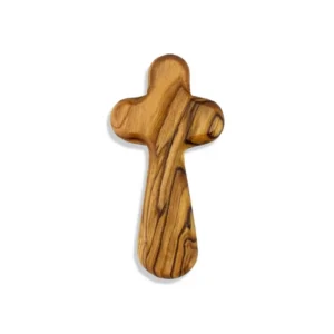 A small hand-carved olivewood holding cross, 5cm by 3cm, held in the palm of a hand as a comfort prayer cross for religious devotional use.